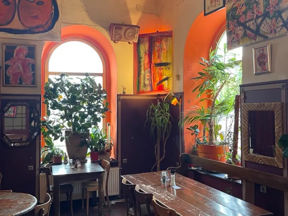 Ein Restaurant, es ist hell. Kunst hängt an der Wand, hölzerner Boden.