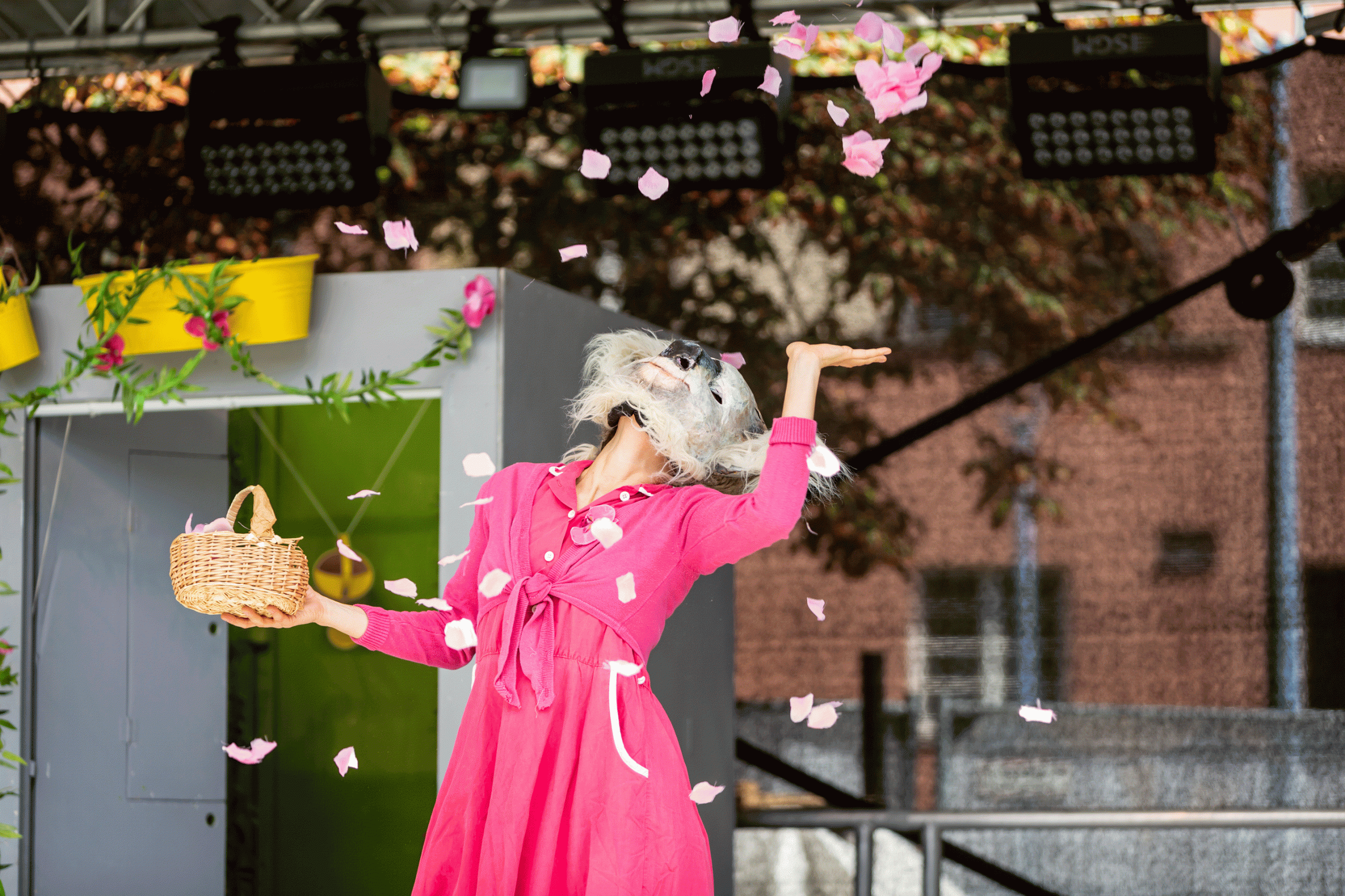 Auf der Bühne ist eine Dame zu sehen, die Blüten in die Höhe wirft.