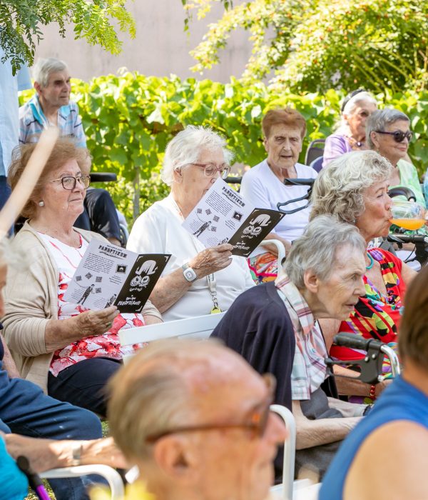 Ältere Menschen sitzen beim Gartenkonzert in den Häusern zum Leben