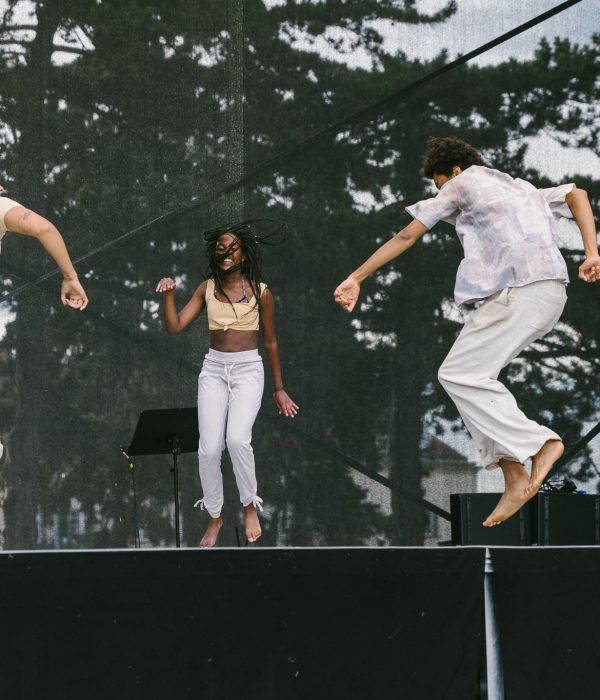 Drei Personen springen und tanzen barfuß